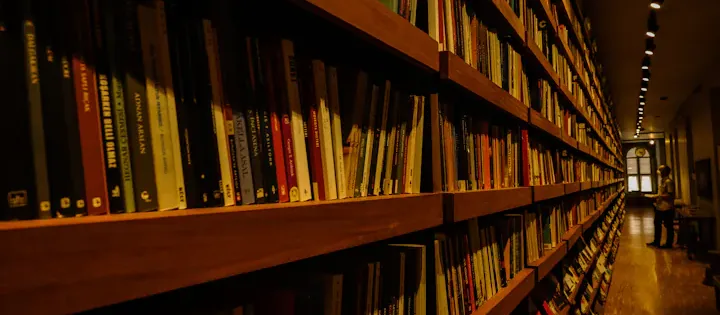 Long shelves filled with books in a warmly lit library interior, representing physical book distribution